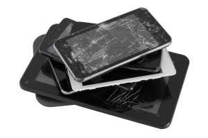 pile of smartphones with cracked screens repair